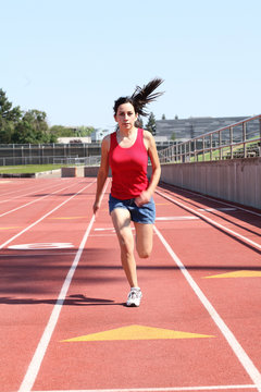 Young Hispanic Teen Girl Running On Track