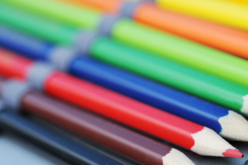 Roter Buntstift in der Reihe von anderen Buntstiften