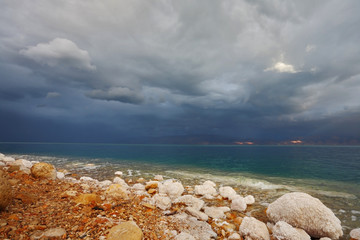 Blue storm cloud  and rocks, overgrown with salt