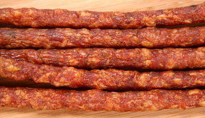 Smoked sausage on a wooden background in close up