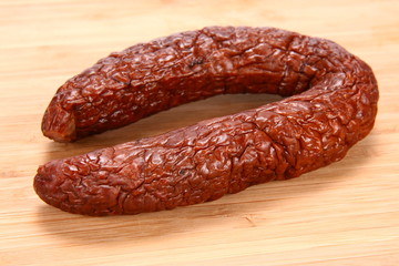 Smoked sausage on a wooden background