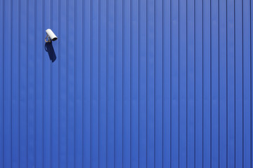 Fototapeta na wymiar cctv video surveillance camera on blue metallic wall