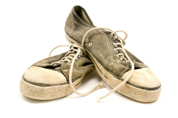 Pair of old and dirty sneakers , isolated on white