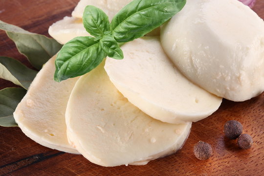 Mozzarella cheese and basil on a wooden board