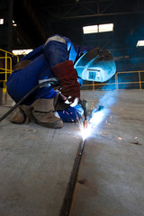 worker weld metal in factory and sparks