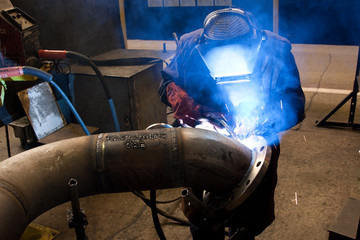 worker weld metal in factory and spark