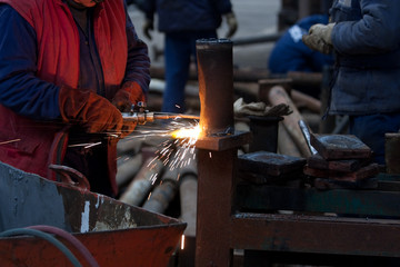 worker inside factory cut metal using blowtorch