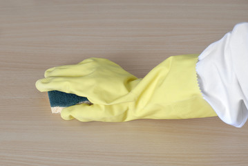 nettoyage: main dans gant jaune avec éponge