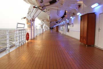 cruise ship deck with wooden floor and turned on lamps