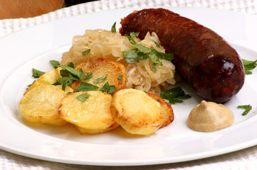 geräucherte Wurst mit Sauerkraut und Röstkartoffeln