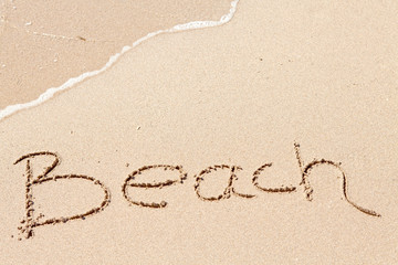 word Beach written on the beach