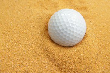 closeup of a golf ball in a sand trap