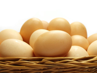 Eggs in a small basket isolated on white background