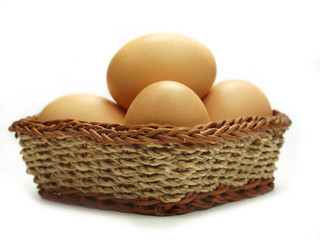 Eggs in a small basket isolated on white background