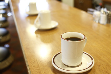 Fototapeta premium Cup of black coffee at a diner