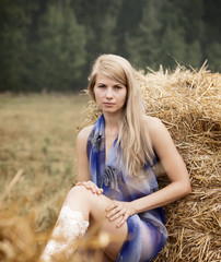 Young sexy woman among the straw.