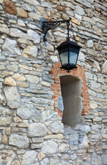 Fototapeta na wymiar Stony wall with window and lamp (Olesko Castle, Ukraine)