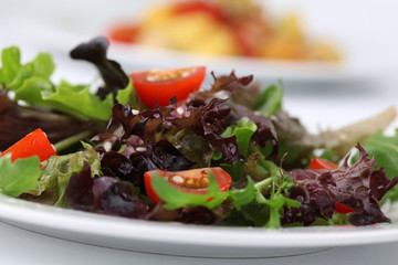 Mixed greens with cherry tomatoes sprinkled with sesame seeds