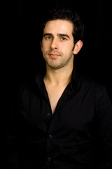 Fototapeta premium Portrait of young attractive man on a black background