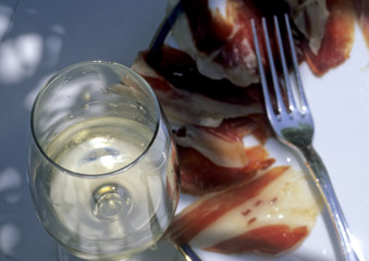 Decorativ table with ham and a glass of vine.