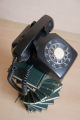 stack of books with vintage telephone on top