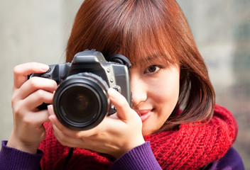 Female photographer using SLR camera.