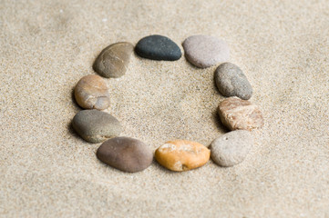 Fototapeta na wymiar lettre O en galets zen dans le sable