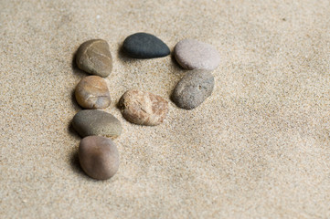 Fototapeta na wymiar lettre P en galets zen dans le sable