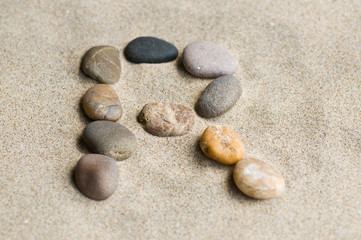 Fototapeta na wymiar Litera R zen kamienie na piasku