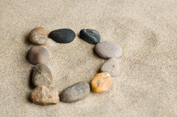 Fototapeta na wymiar lettre D en galets zen dans le sable