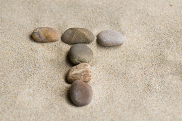 Fototapeta na wymiar Litera T Pebble Zen w piasku