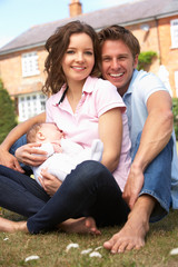 Parents Cuddling Newborn Baby Boy Outdoors At Home