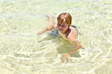 happy boy enjoys the crystal clear water