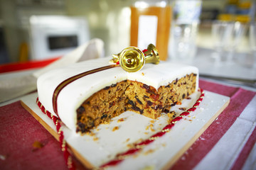 Christmas cake with golden bells and red ribbon.