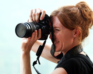 Fototapeta na wymiar Piękna Kobieta Fotograf z czerwonymi włosami