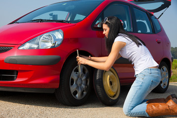 Fototapeta na wymiar Frau mit einer Reifen Panne beim Auto