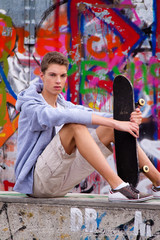 Obraz na płótnie Canvas Cool blickender Jugendlicher Mann vor Graffiti