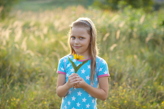Little smiling girl with yellow flower