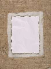 Burned and crumpled paper on  linen background.