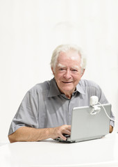 Fototapeta premium Älterer Herr mit Netbook und Webcam