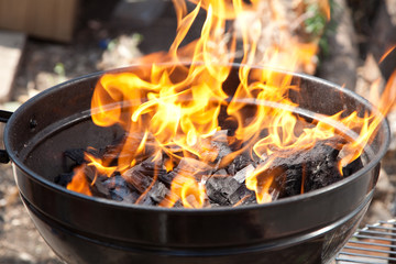 A grill with charcoal and flames