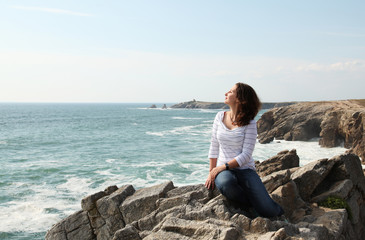 Naklejka na ściany i meble Young girl enjoying wind and the ocean