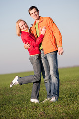 Young couple walking through summer lawn