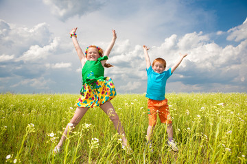 Two golden-haired children playin the field