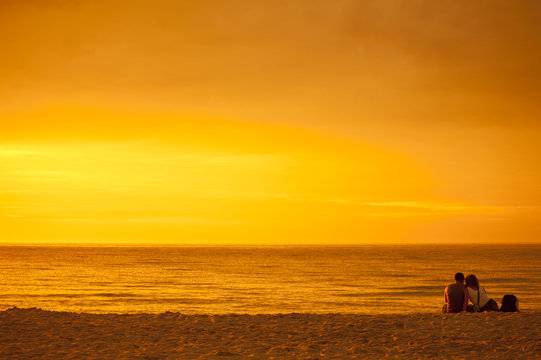 Zakochana para podziwiająca zachód słońca nad morzem © sitriel