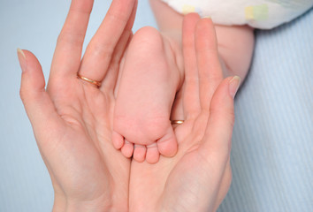 Heel of the baby in hands of mum