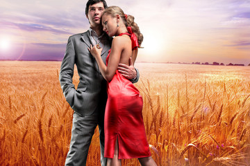 Portrait young beautiful couple under Golden wheat ready for har