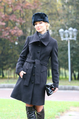 Beautiful blonde outdoors in coat and hat