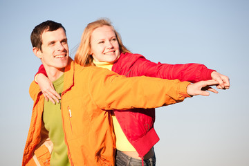 Young love couple smiling under blue sky