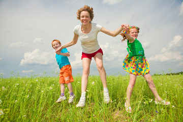 Fototapeta premium mother with children goes on field